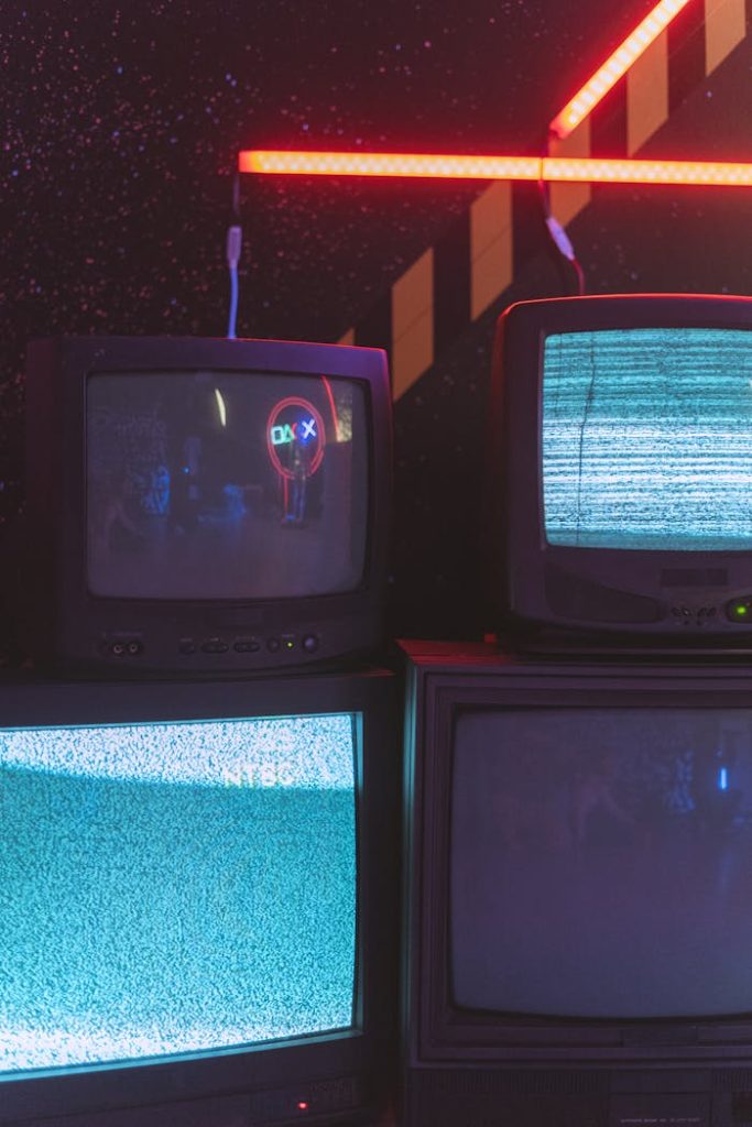 Mastering the First Impression: Your intriguing post title goes here A collection of old CRT televisions displaying static noise under vibrant neon lighting.